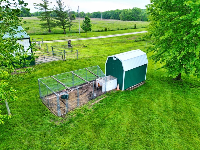 view of yard featuring a rural view, an outdoor structure, and a storage unit