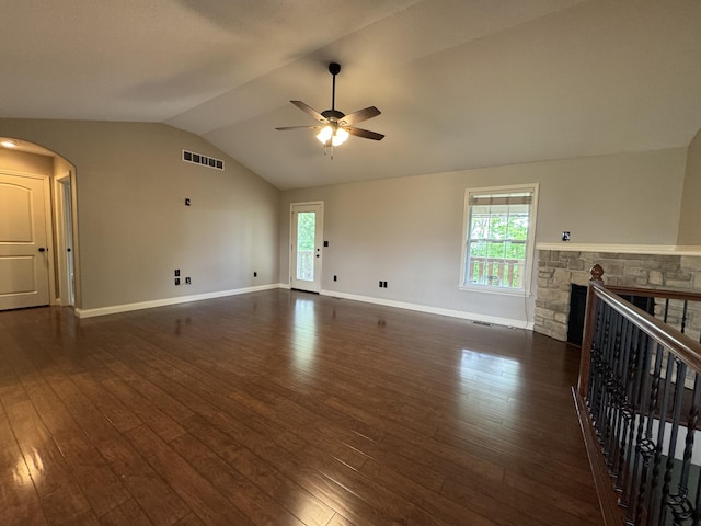 unfurnished living room featuring vaulted ceiling, a ceiling fan, dark wood-style flooring, a fireplace, and healthy amount of natural light