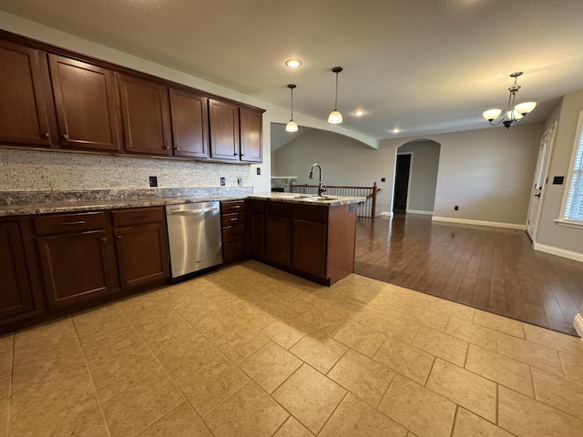 kitchen featuring dishwasher, arched walkways, open floor plan, a peninsula, and dark brown cabinets