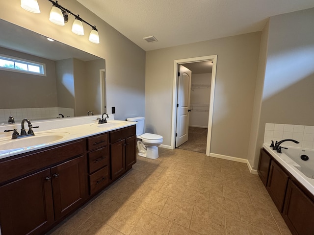 full bathroom featuring a garden tub, toilet, double vanity, tile patterned flooring, and baseboards