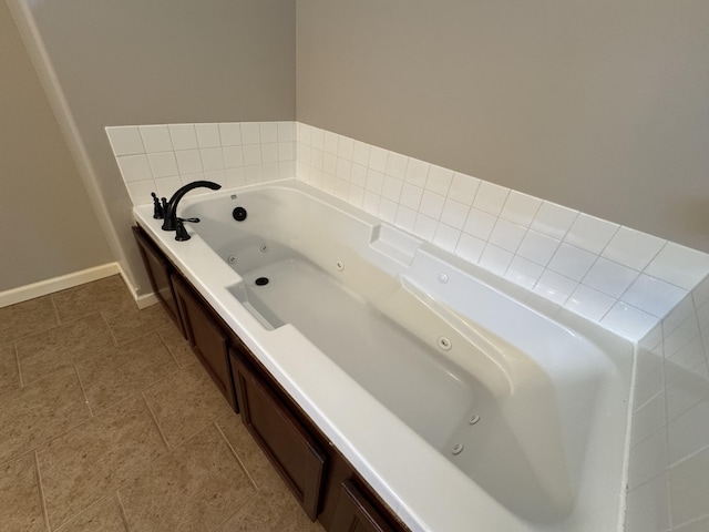 bathroom with a jetted tub and baseboards