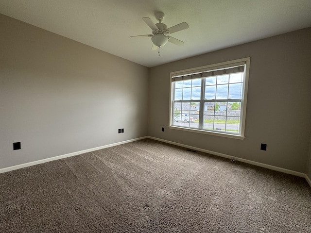 empty room with baseboards, a ceiling fan, and carpet