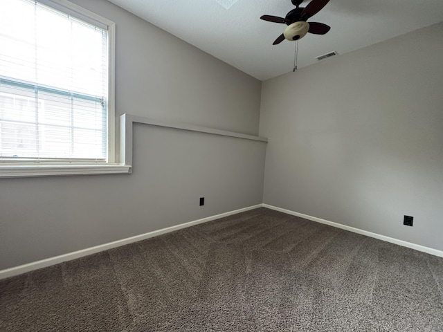 spare room with a ceiling fan, healthy amount of natural light, carpet floors, and baseboards