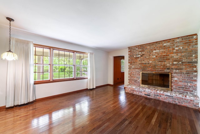 10155 E Union Church Rd, Centralia, MO 65240 - unfurnished living room featuring hardwood / wood-style floors, baseboards, and a brick fireplace