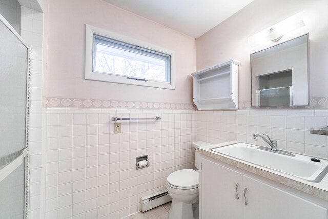 10155 E Union Church Rd, Centralia, MO 65240 - bathroom featuring baseboard heating, tile walls, toilet, wainscoting, and vanity