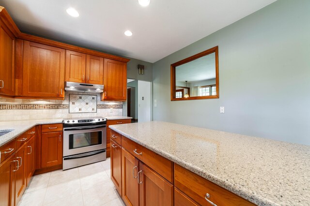 10155 E Union Church Rd, Centralia, MO 65240 - kitchen with stainless steel electric range, under cabinet range hood, brown cabinetry, backsplash, and recessed lighting