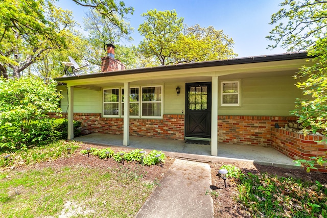 10155 E Union Church Rd, Centralia, MO 65240 - view of exterior entry featuring a porch, a chimney, and brick siding