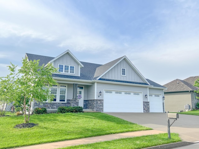 craftsman house with a front lawn, stone siding, board and batten siding, and a garage