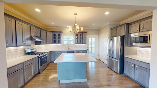 5492 Diversey Rdg, Columbia, MO 65203 - kitchen with stainless steel appliances, under cabinet range hood, a chandelier, a kitchen island, and glass insert cabinets