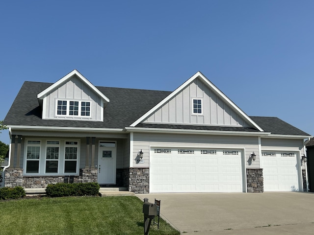 5492 Diversey Rdg, Columbia, MO 65203 - view of front facade featuring stone siding, an attached garage, concrete driveway, board and batten siding, and a front yard