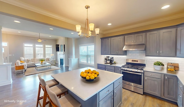 5492 Diversey Rdg, Columbia, MO 65203 - kitchen with stainless steel gas stove, under cabinet range hood, light wood-style flooring, a kitchen breakfast bar, and gray cabinets