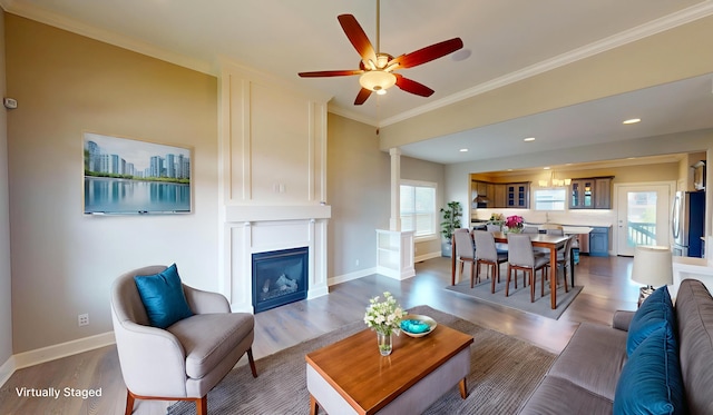 5492 Diversey Rdg, Columbia, MO 65203 - living room featuring dark wood-style flooring, ceiling fan, ornamental molding, a glass covered fireplace, and recessed lighting