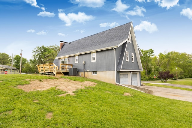 rear view of house featuring a garage, central AC unit, concrete driveway, roof with shingles, and a wooden deck
