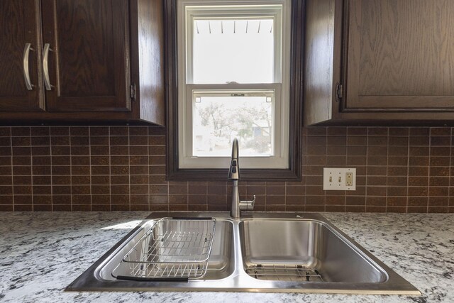 kitchen featuring a sink, dark brown cabinets, and backsplash