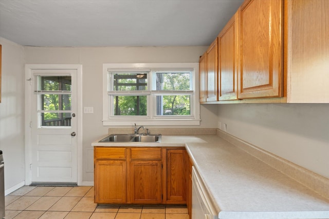 kitchen featuring a sink, light countertops, plenty of natural light, and light tile patterned floors