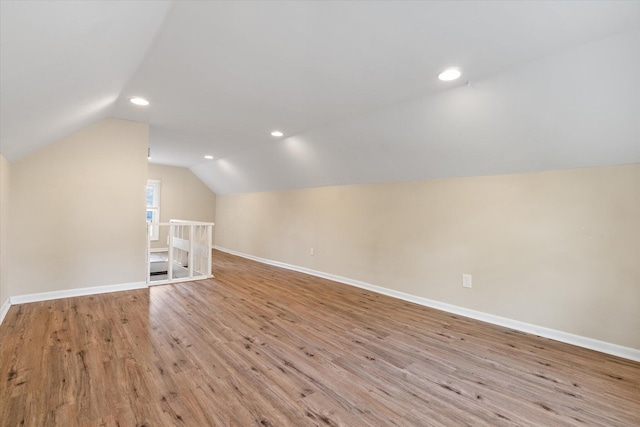 bonus room featuring lofted ceiling, wood finished floors, baseboards, and recessed lighting