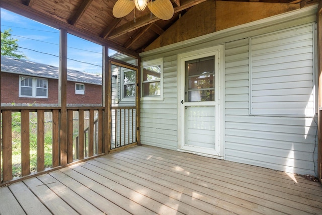 unfurnished sunroom featuring lofted ceiling, a ceiling fan, and healthy amount of natural light