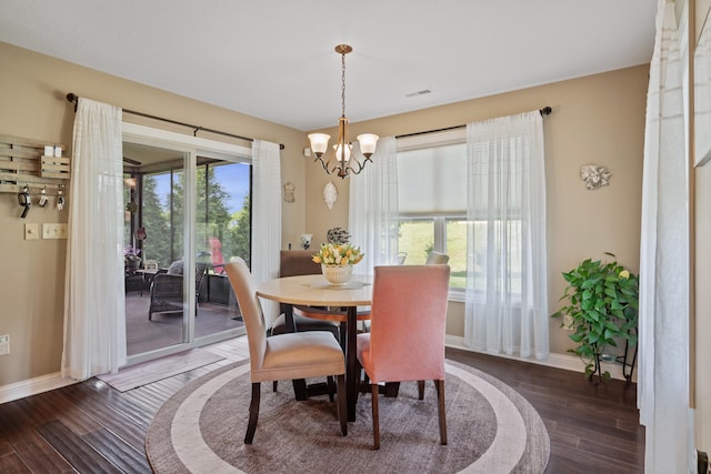 dining space featuring a chandelier, wood finished floors, and baseboards