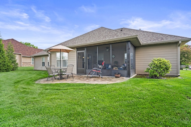 rear view of property featuring a patio, a shingled roof, a yard, and a sunroom