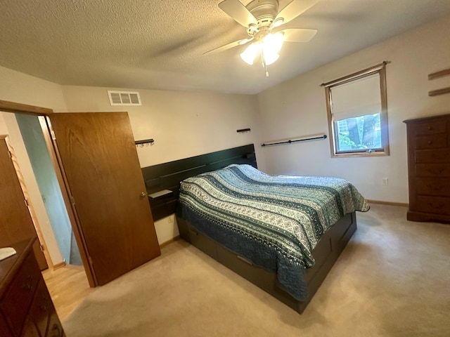 carpeted bedroom featuring a ceiling fan, baseboards, and a textured ceiling
