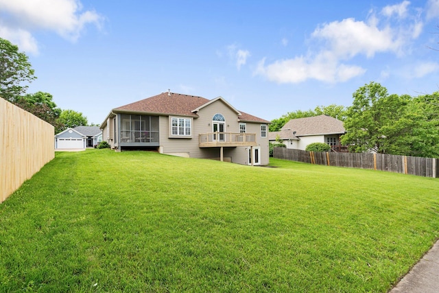 back of property featuring a sunroom, a shingled roof, and a deck
