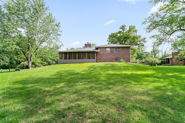 4 Halley Ct, Fulton, MO 65251 - rear view of house featuring a sunroom, a yard, brick siding, and a chimney