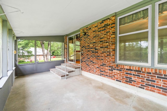 4 Halley Ct, Fulton, MO 65251 - unfurnished sunroom featuring concrete floors, brick wall, and vaulted ceiling