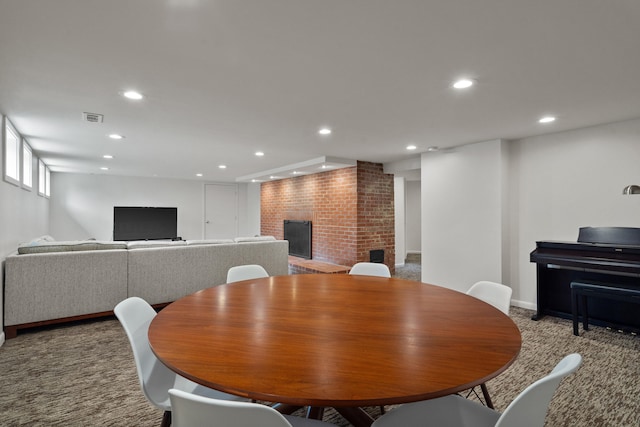 carpeted dining room with a brick fireplace, recessed lighting, and baseboards