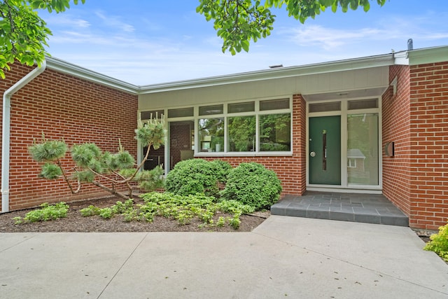 entrance to property featuring brick siding