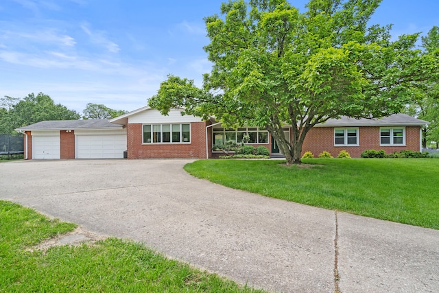 single story home with brick siding, concrete driveway, a front lawn, and an attached garage