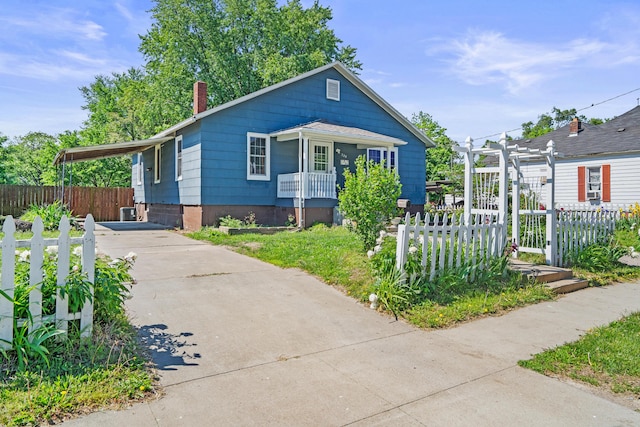 bungalow-style home with driveway, fence, a chimney, and a pergola