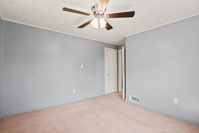 carpeted empty room with crown molding, ceiling fan, and baseboards