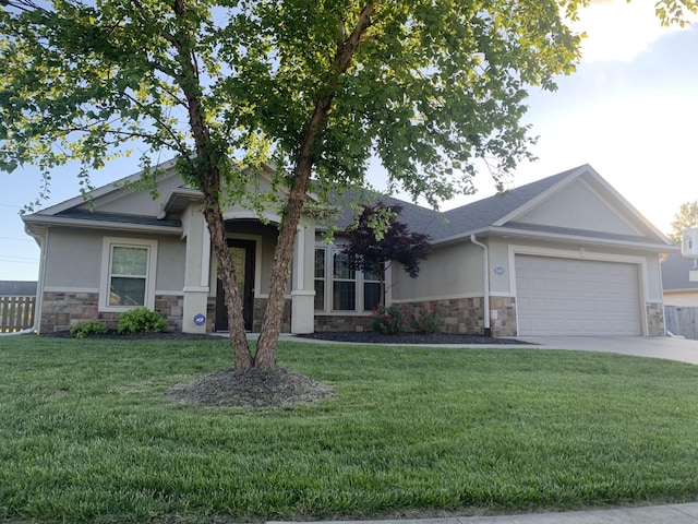 view of front of house featuring stone siding, stucco siding, a garage, and driveway