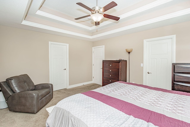 bedroom with a tray ceiling, carpet flooring, baseboards, ornamental molding, and a ceiling fan