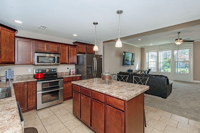 kitchen featuring stainless steel appliances, light tile patterned floors, open floor plan, a kitchen island, and recessed lighting
