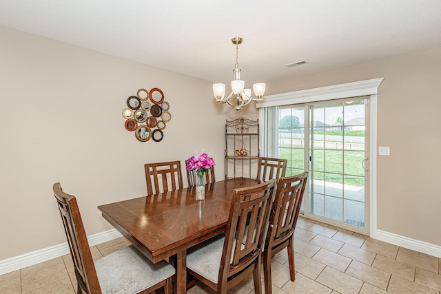 dining space featuring a chandelier, light tile patterned flooring, and baseboards