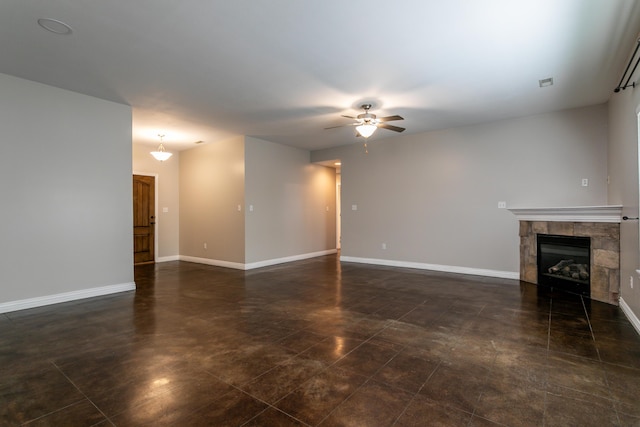 unfurnished living room with ceiling fan, a tile fireplace, and baseboards