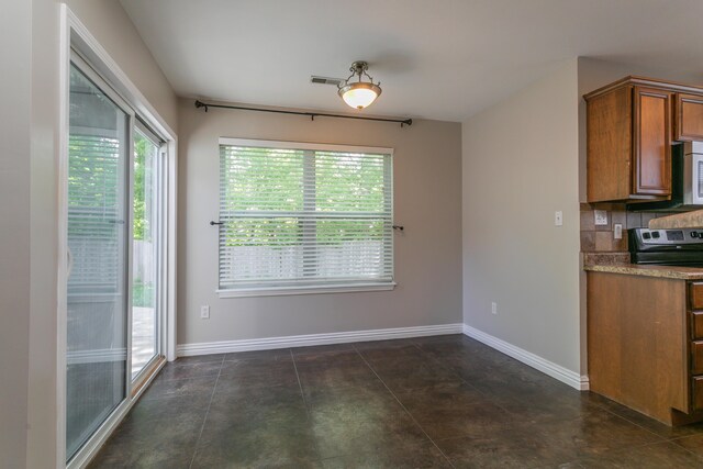 unfurnished dining area featuring baseboards