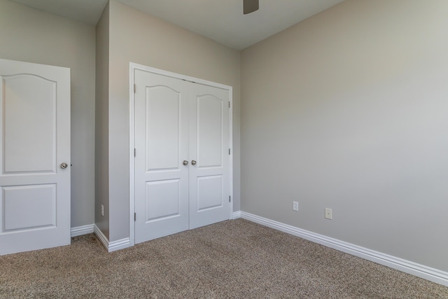unfurnished bedroom featuring carpet, baseboards, a closet, and ceiling fan