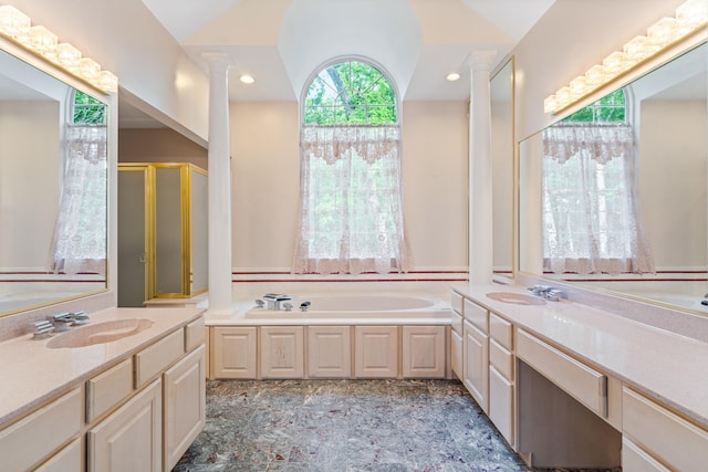 full bathroom featuring decorative columns, a garden tub, two vanities, lofted ceiling, and a shower stall