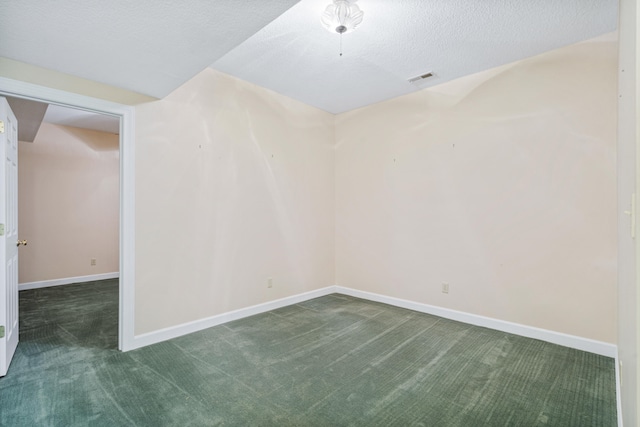 empty room with carpet flooring, baseboards, and a textured ceiling