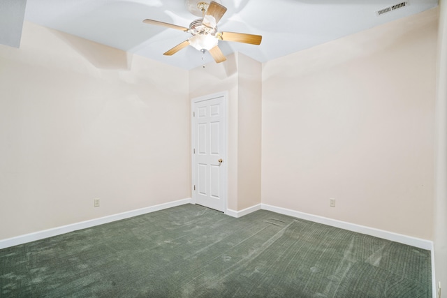 spare room with dark carpet, ceiling fan, and baseboards