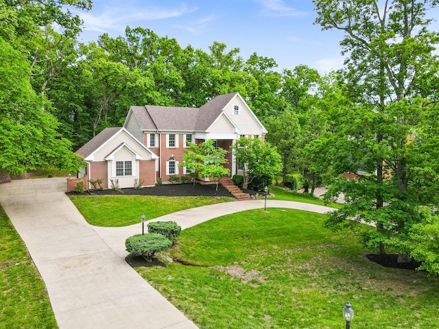 view of front of home featuring brick siding, driveway, a front lawn, and a shingled roof
