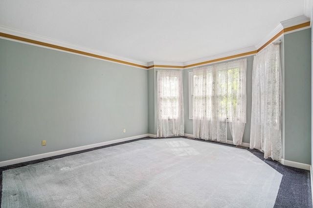 carpeted empty room with crown molding and baseboards