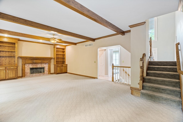 unfurnished living room featuring light carpet, ceiling fan, baseboards, beam ceiling, and ornamental molding