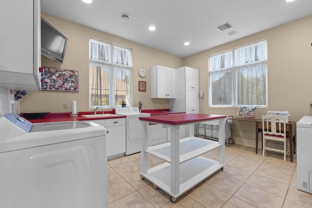 kitchen featuring washer and clothes dryer, light tile patterned floors, recessed lighting, a sink, and white cabinetry