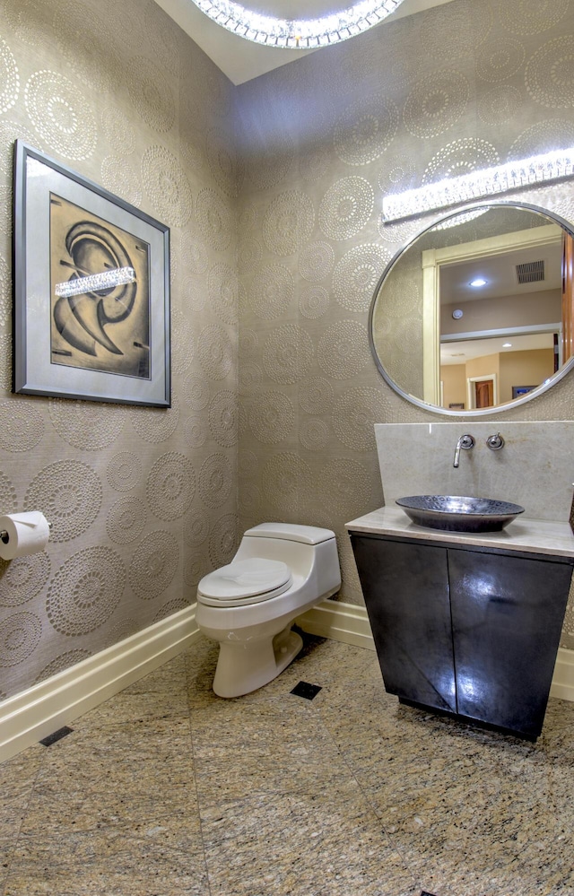 bathroom with baseboards, toilet, and vanity