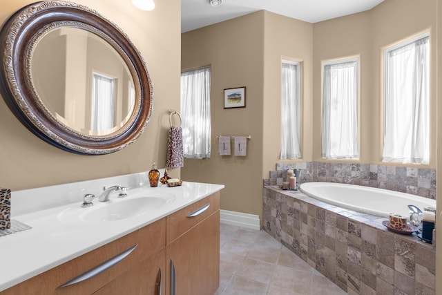 full bath with baseboards, vanity, a garden tub, and tile patterned flooring