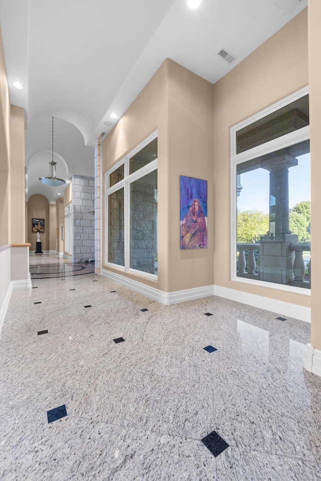 hallway with arched walkways, baseboards, ornate columns, and recessed lighting