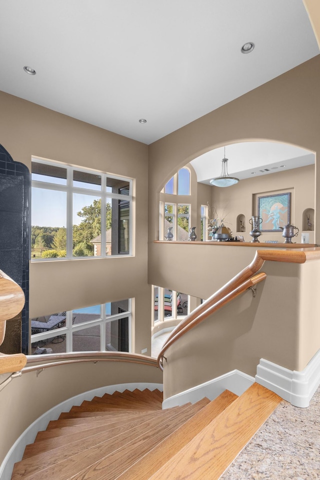 staircase featuring baseboards and recessed lighting